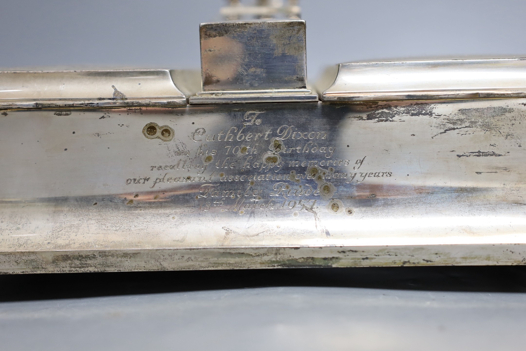 A George V silver mounted two handled desk top twin cigarette box incorporating a cigar cutter and lighters, with 1957 presentation inscription, Mappin & Webb, London, 1926, width 33.5cm.